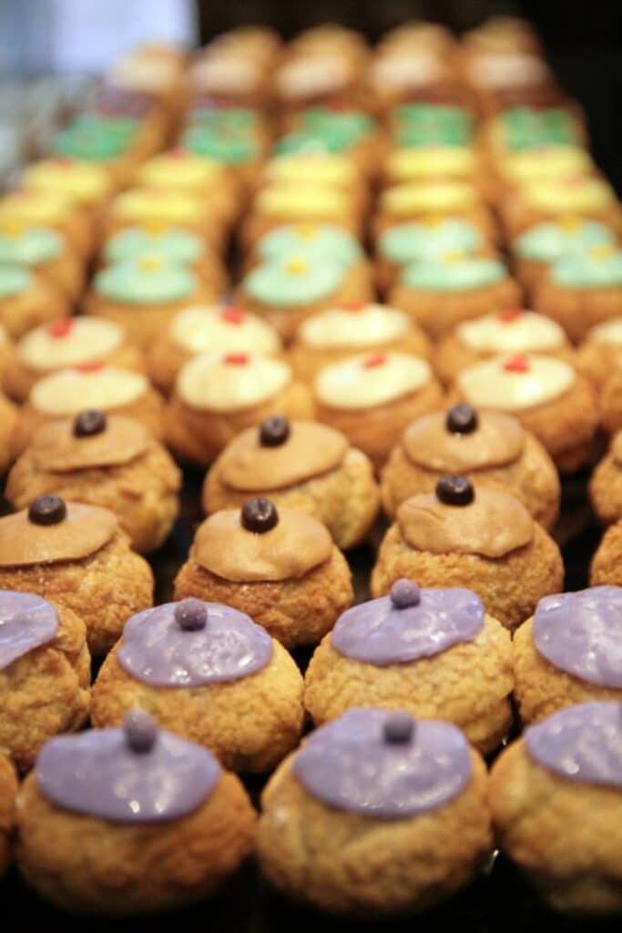 Close-up of colorful cream-filled pastries in neat rows.