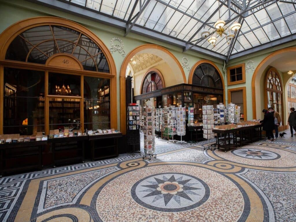Parisian passage interior with bookshop and mosaic floor.