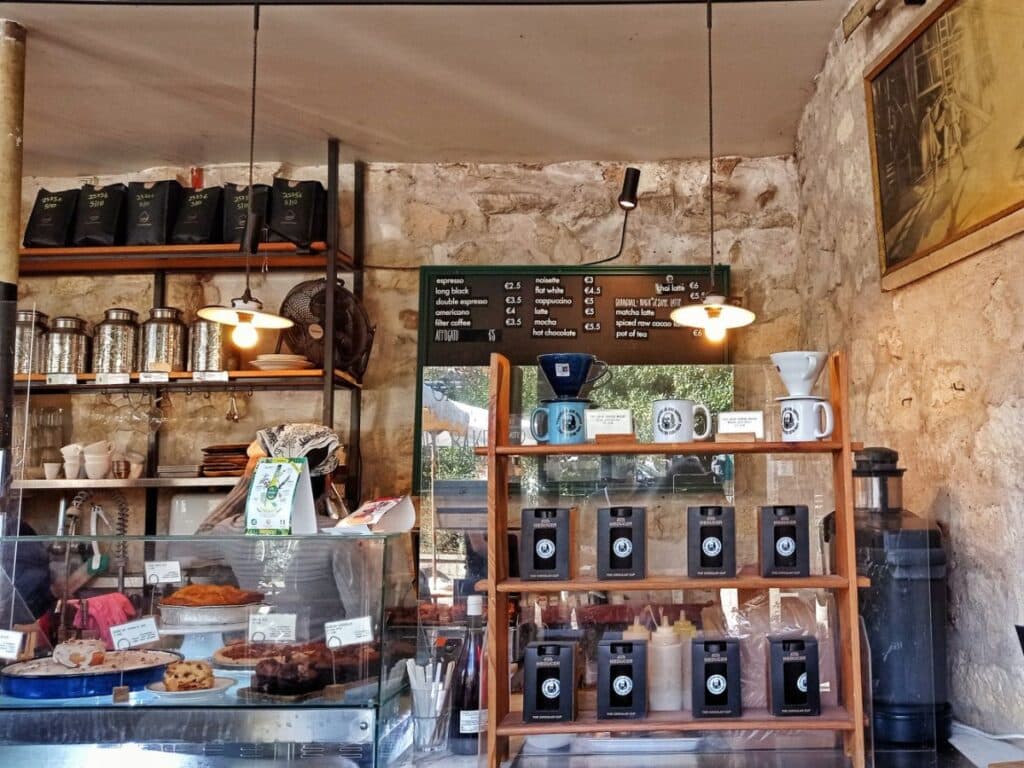Rustic coffee shop interior with baked goods and coffee bags.