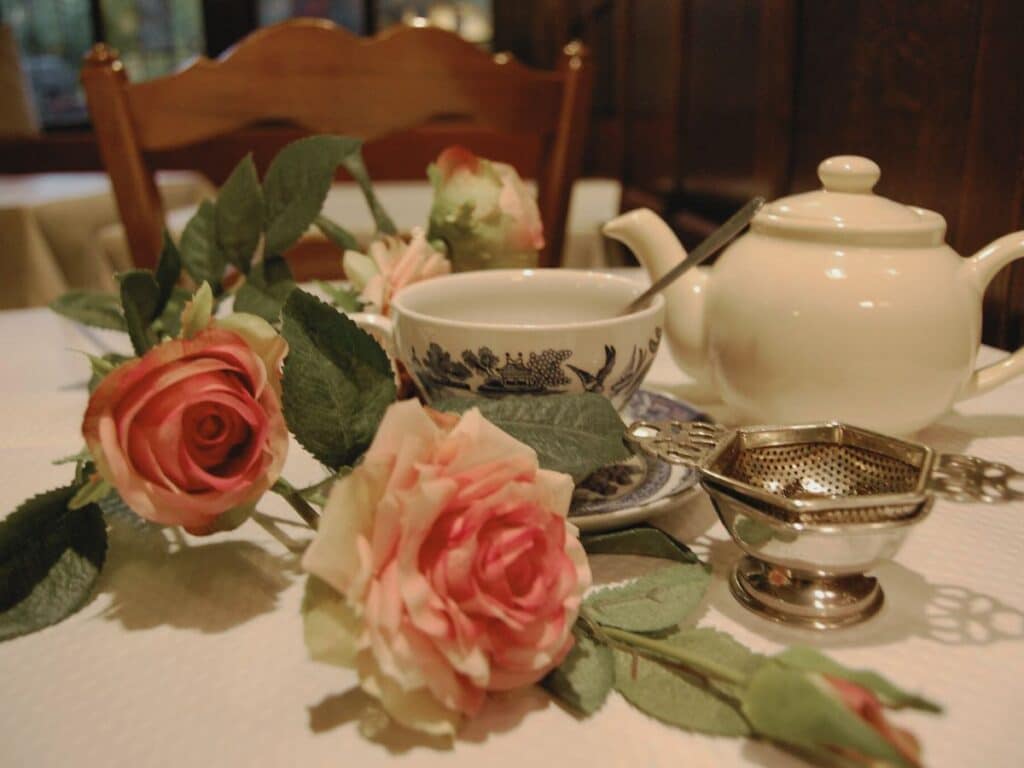 Traditional tea setting with roses and a classic teapot.