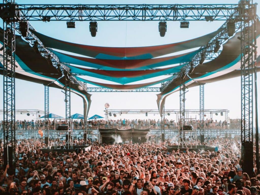The Delta Festival with a big music structure and hundreds of people listening.