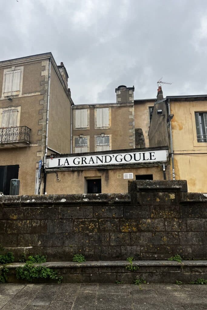 Exterior of La Grand'Goule nightclub in Poitiers, France, with a sign bearing its name on the front of a beige building with shuttered windows.