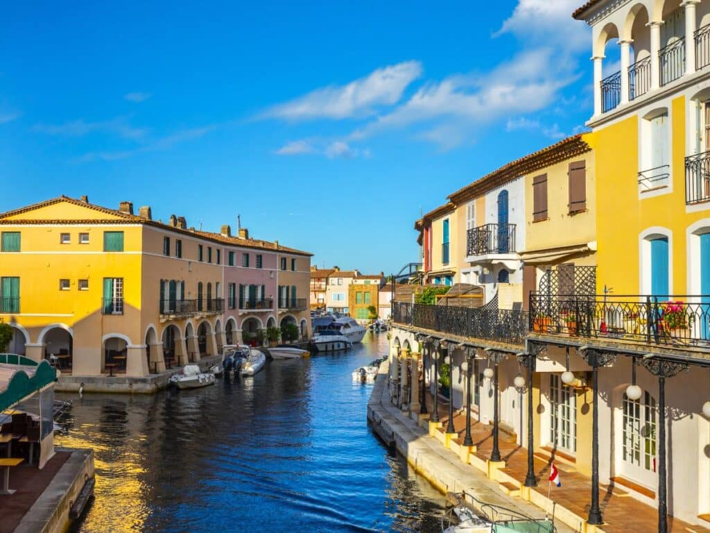 Colorful waterside houses with boats docked along the canals of Port Grimaud, a unique hidden gem in the South of France.