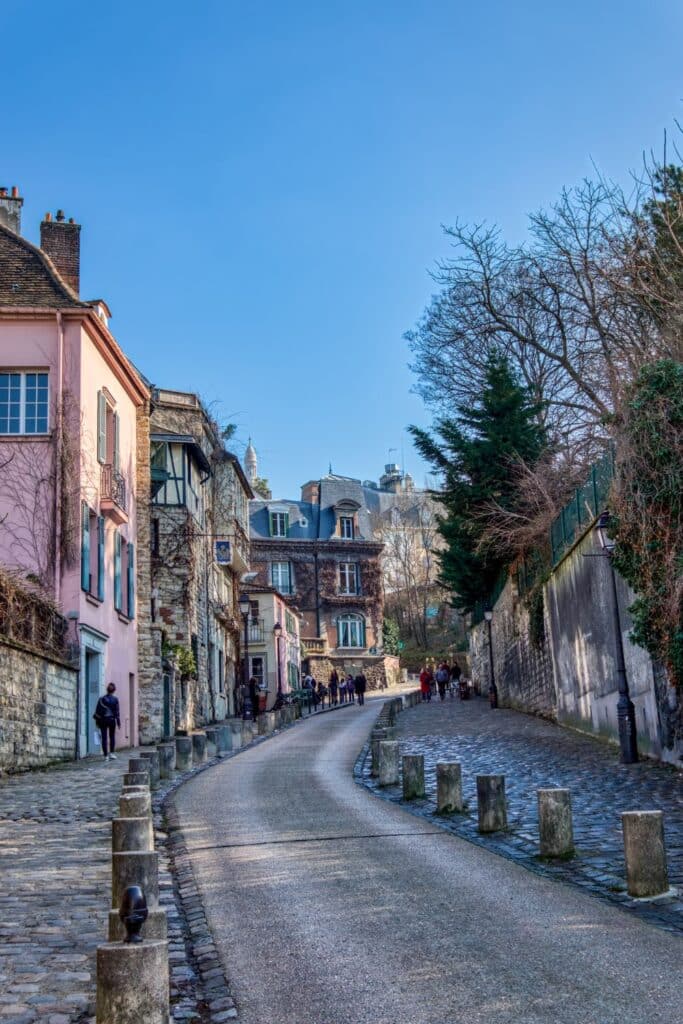 Various iconic Parisian locations featured in the show "Emily in Paris." The montage includes cobblestone streets, picturesque pastel-colored buildings, and charming cafés typical of the Montmartre neighborhood.