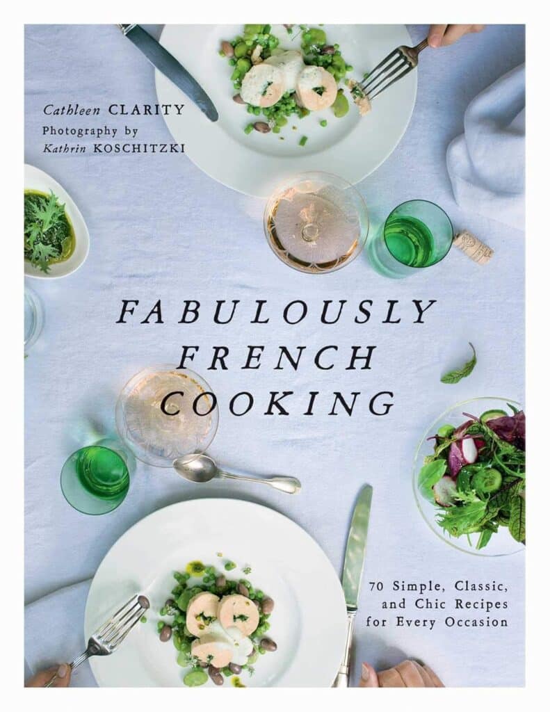 The cover of Fabulously French Cooking by Cathleen Clarity displays an elegant overhead view of a refined French meal setting, with dishes arranged on a white tablecloth, promising "70 Simple, Classic, and Chic Recipes for Every Occasion." The design evokes a fresh, sophisticated approach to French cuisine.