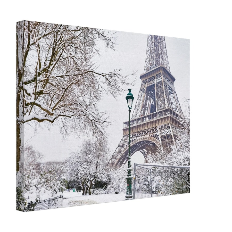 A winter-themed canvas print of the Eiffel Tower in Paris, framed by snow-covered trees and a vintage-style lamppost, evoking the serene, magical atmosphere of a snowy Parisian day.