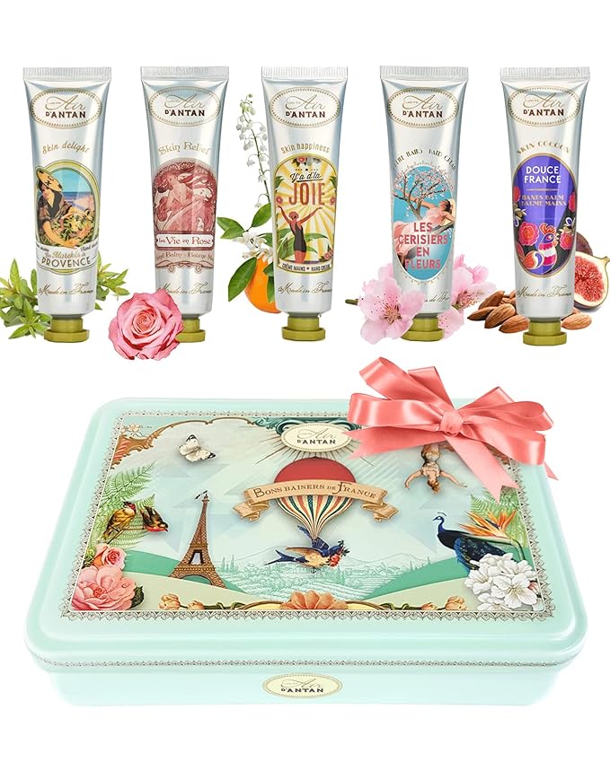 A French-themed gift set of luxurious hand creams in a decorative tin, adorned with vintage-style illustrations of Paris and florals. Each cream is uniquely scented, reflecting French-inspired themes such as "La Vie en Rose" and "Douce France," and packaged with a charming pink ribbon for a refined touch.