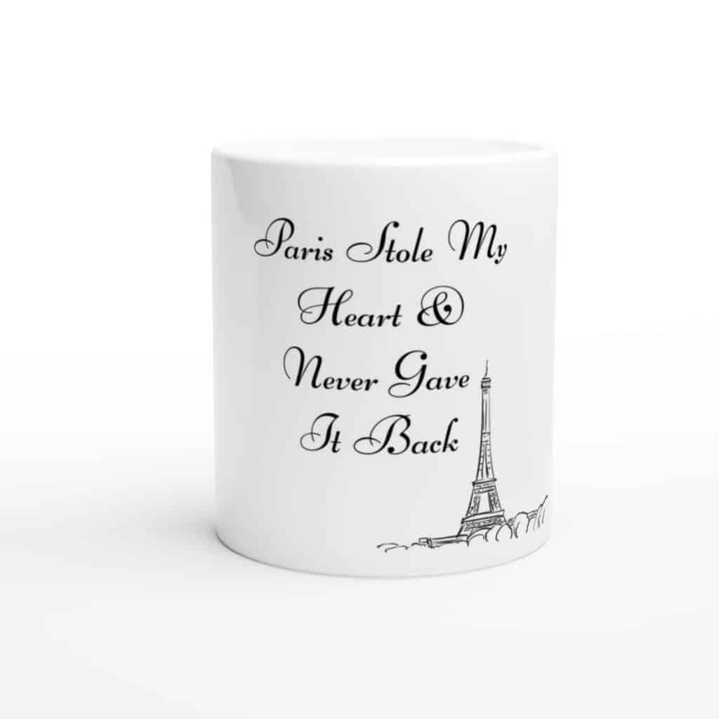 Another white mug features the romantic message "Paris Stole My Heart & Never Gave It Back," accompanied by a sketch of the Eiffel Tower, celebrating the deep affection for the city.