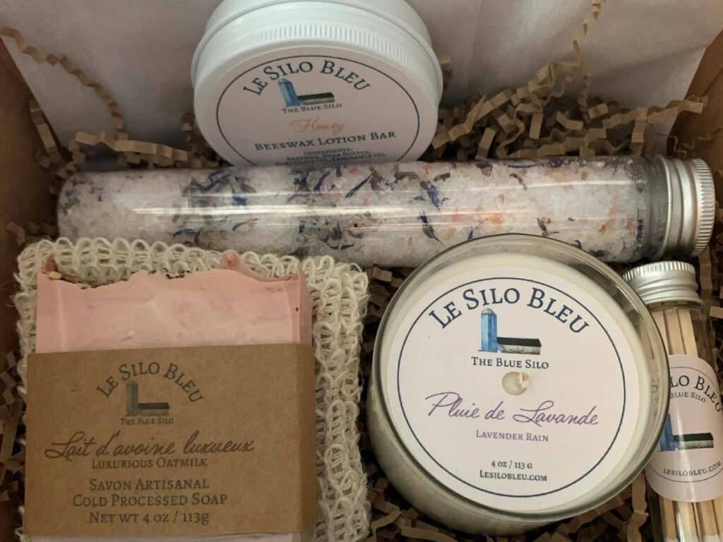 A soothing spa set by Le Silo Bleu, including lavender bath salts, beeswax lotion bar, handcrafted oatmeal soap, and a lavender-scented candle, presented in rustic packaging for a luxurious self-care experience.