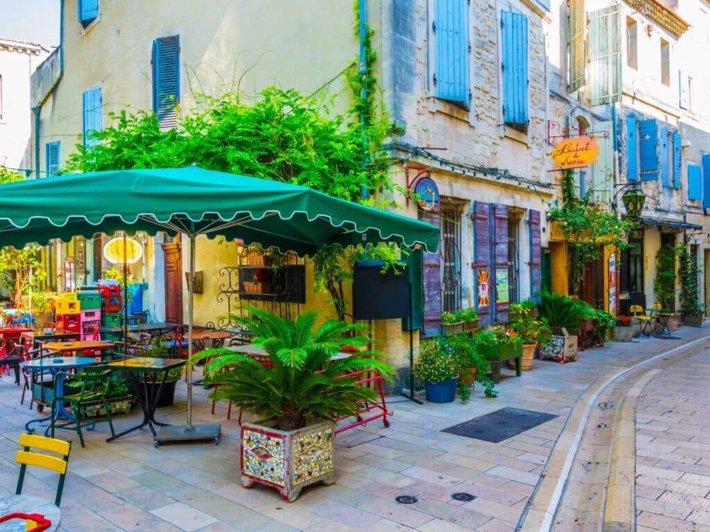 A charming French village square adorned with greenery and café tables, symbolizing the laid-back lifestyle that attracts Americans moving to France.