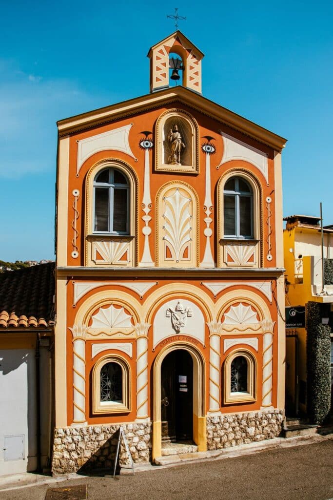 The beautifully decorated facade of Chapelle Saint-Pierre in Villefranche-sur-Mer, featuring intricate patterns and vibrant hues, a notable landmark and photo spot.