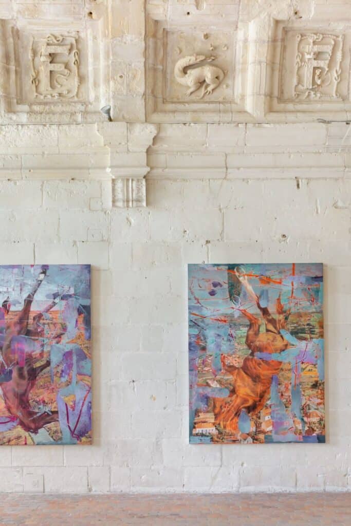 A fusion of history and modernity inside Château de Chambord, where colorful abstract paintings are displayed against ancient stone walls adorned with Renaissance carvings.