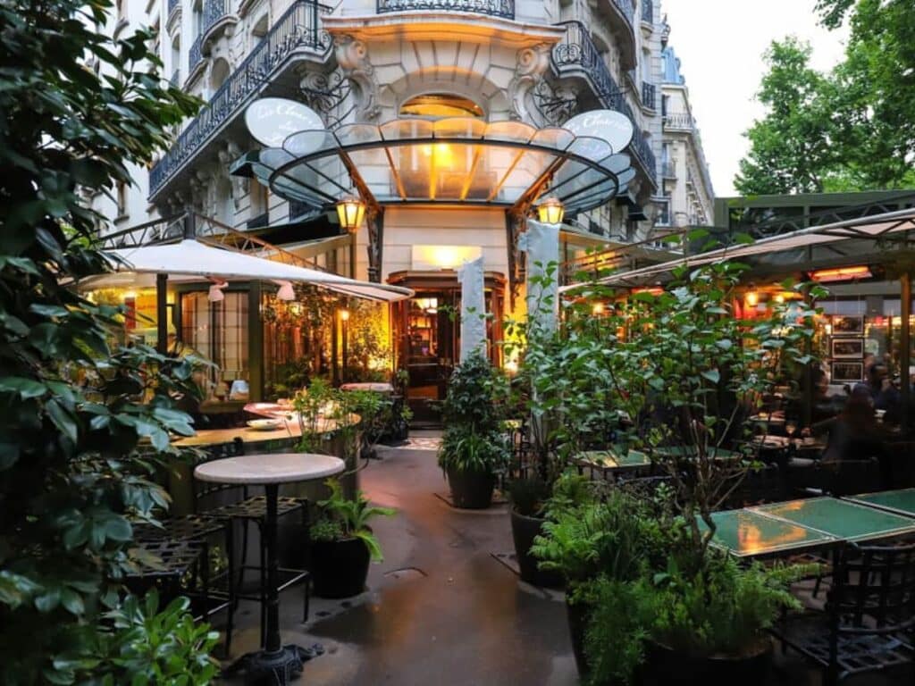 Elegant garden entrance to La Closerie des Lilas, a famous Paris cafe known for its leafy, romantic patio setting, art nouveau architecture, and historic literary clientele.
