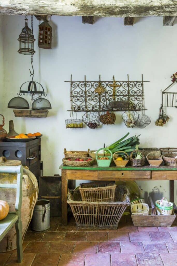 Rustic French peasant kitchen with baskets of fresh produce like carrots, leeks, and onions, ideal ingredients for traditional French onion soup.