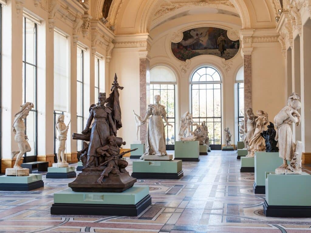 Elegant gallery space in the Petit Palais with classical sculptures displayed under arched ceilings and tall windows. A must-see destination among free museums in Paris for art lovers.